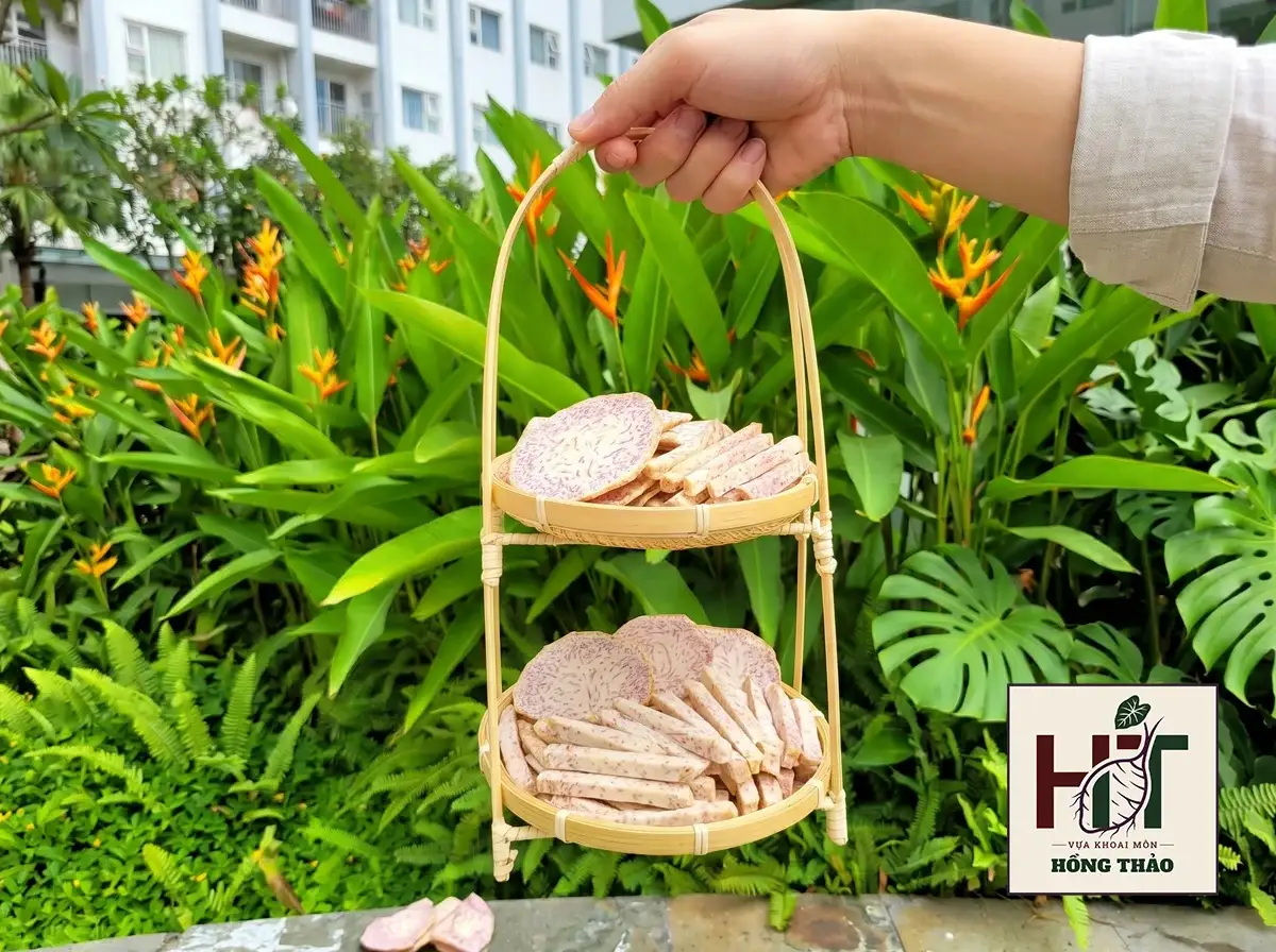 Thành phẩm khoai môn chỉ tím sấy giòn dạng lát và dạng sợi được bày trên khay mây tre.