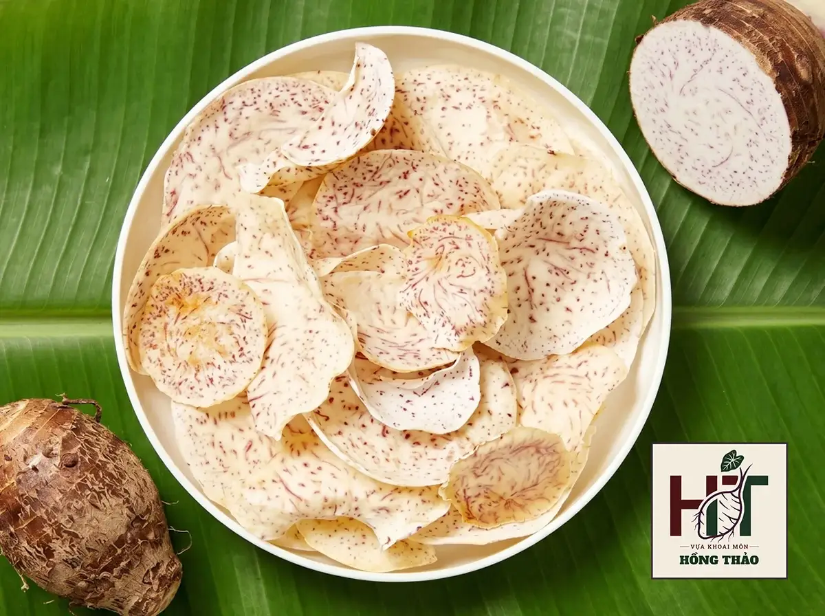 Đĩa khoai môn sấy thái lát mỏng giòn rụm, nổi bật vân chỉ tím làm snack ăn vặt.